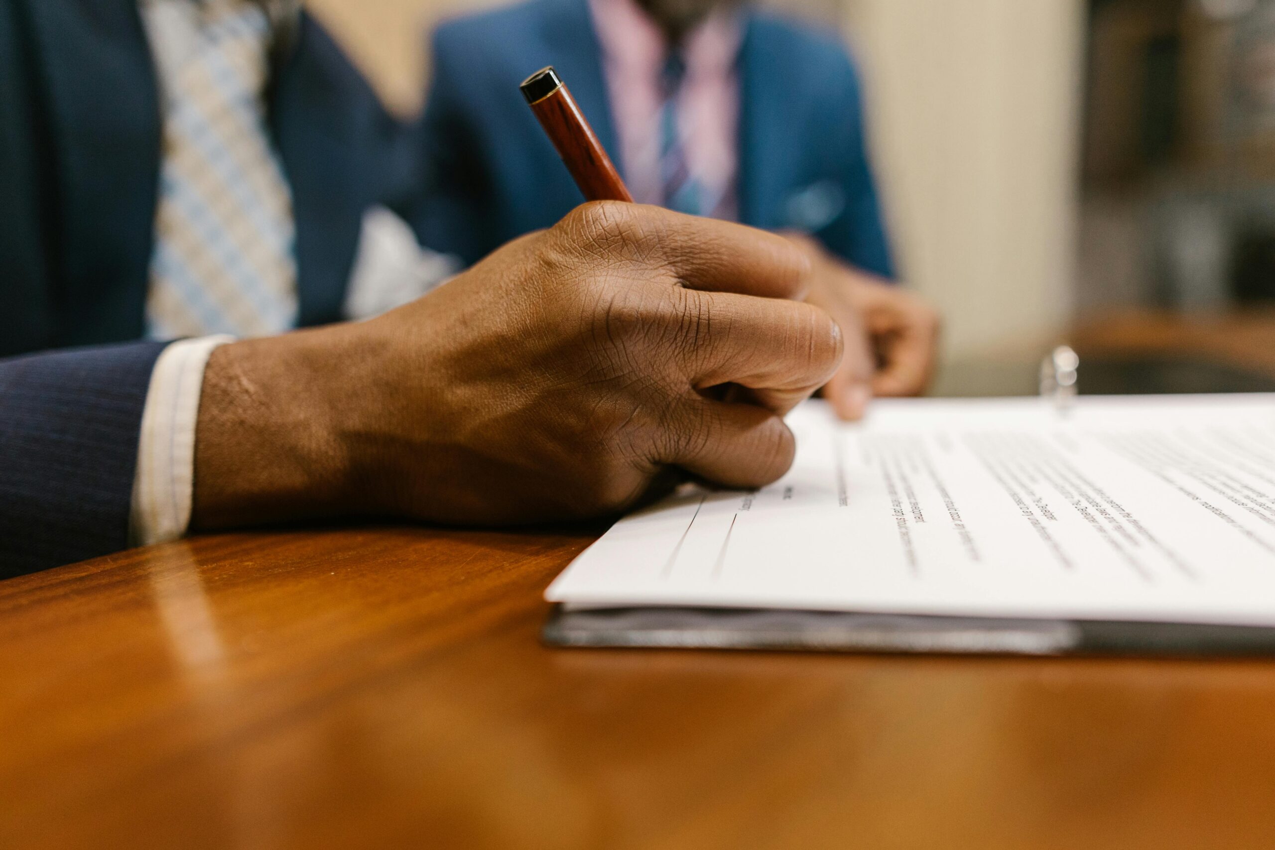 Close-Up Shot of a Person Writing on a Contract